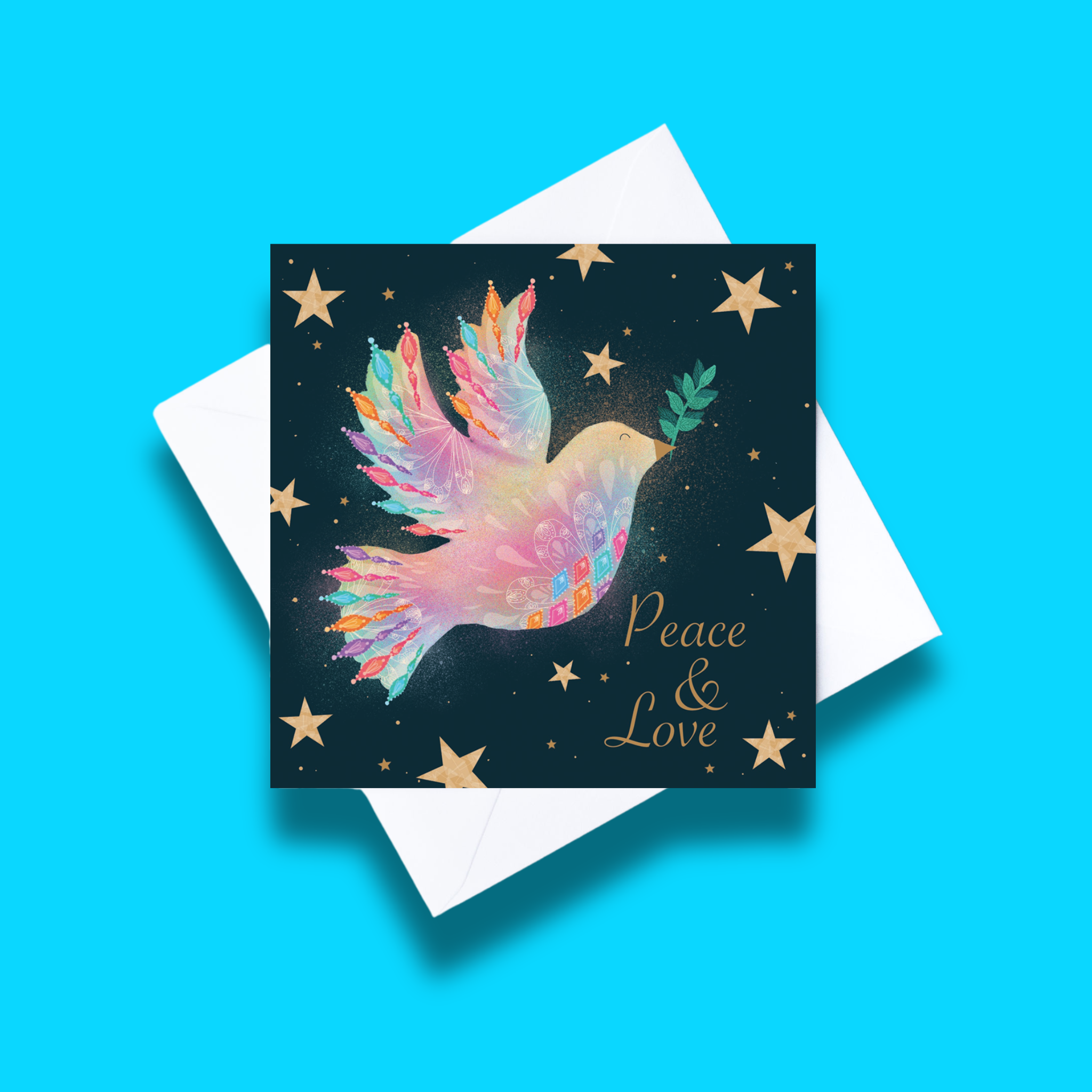 Peace and Love Christmas card with white envelope on a blue background. Card design features a colourful dove on a dark starry background and text that says Peace and Love