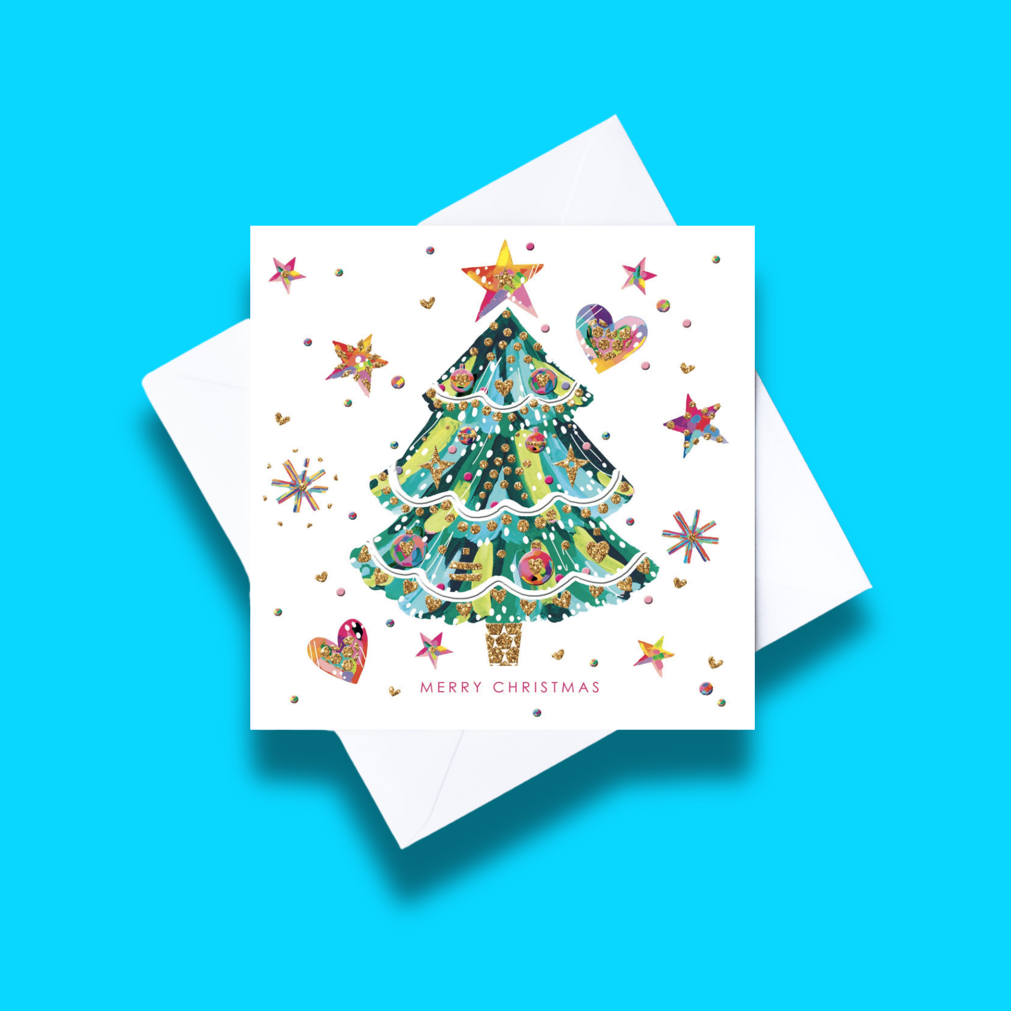 Starry Christmas Christmas card with white envelope on a blue background. Card design features a colourful Christmas tree with a star on top on a white background with coloured hearts, stars and circles for decoration