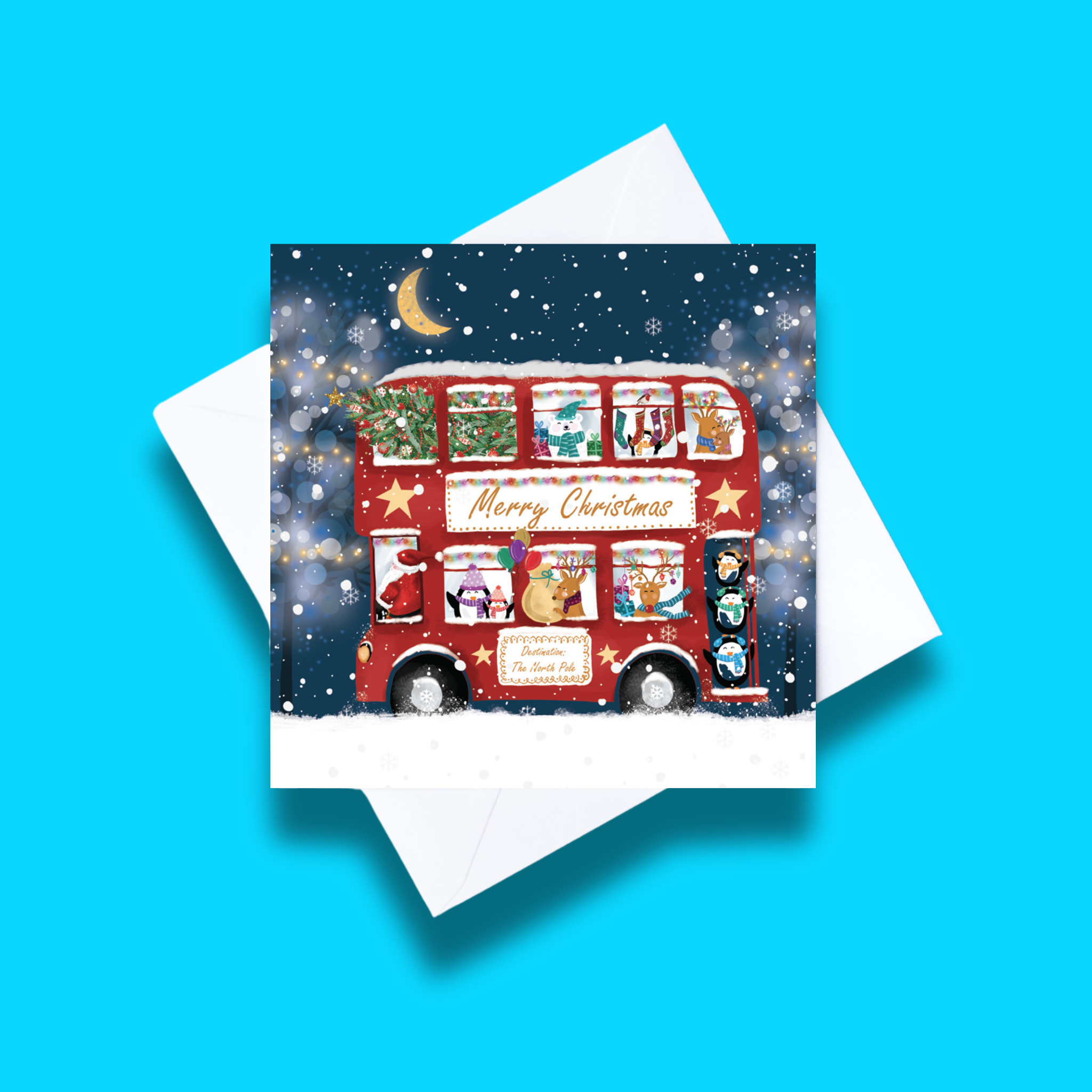 The Santa Bus Christmas card with white envelope on a blue background. Card design features a  bus with festive animals and Sana on a starry snowy background